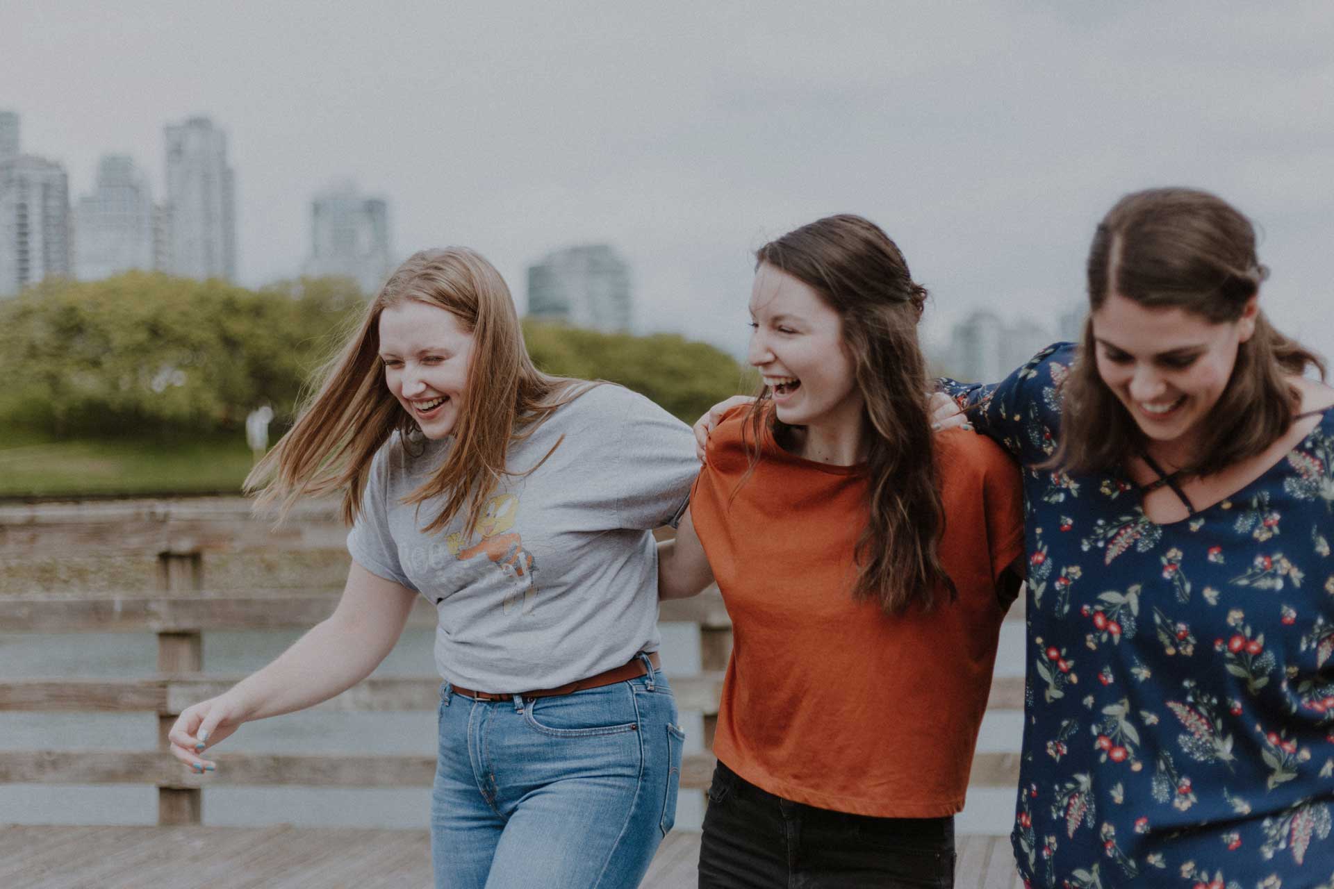 Group of teenage girls laughing with arms around eachother