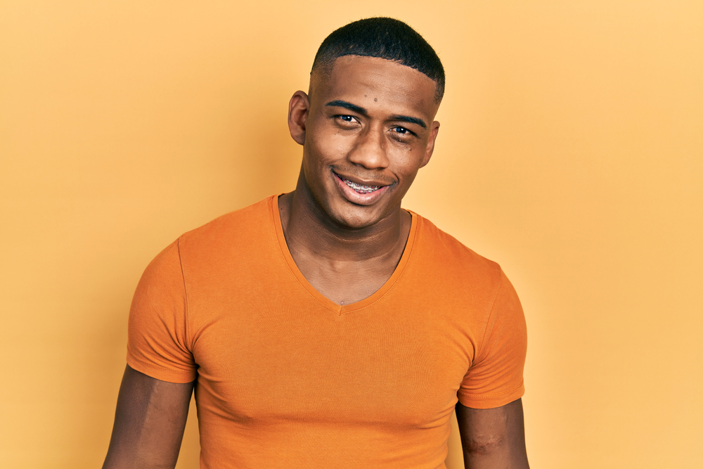 Young,Black,Man,Wearing,Casual,Orange,T,Shirt,Looking,Positive Traditional Metal Braces in South Riding: Are They Still the Most Effective Option?